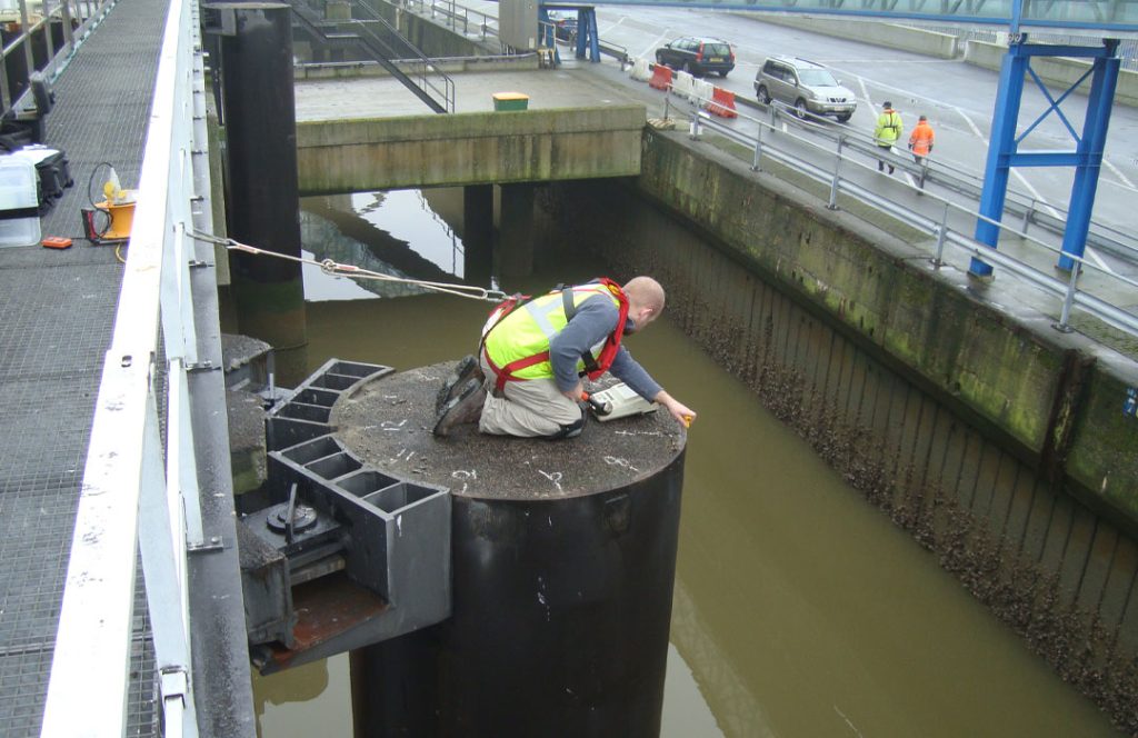 Pile integrity testing being conducted on a concrete pile in a marine structure